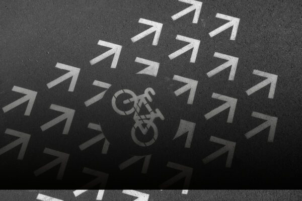 Bicycle path on stone pavement in city in black and white. Signs and symbols in urban area.