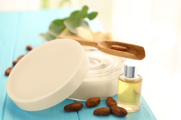 close up of cream product next to nuts and a yellow product