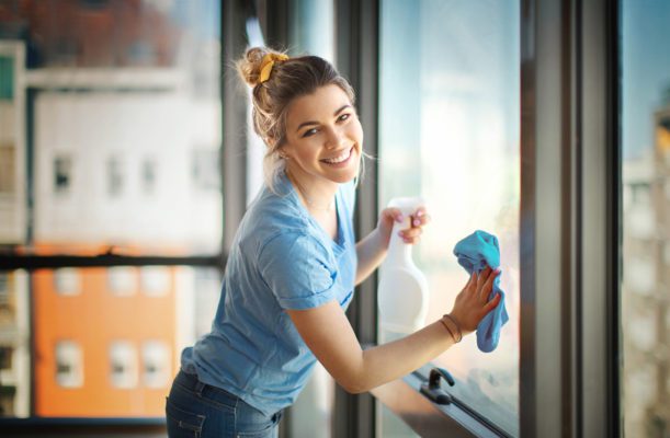 woman cleaning windows in her apartment