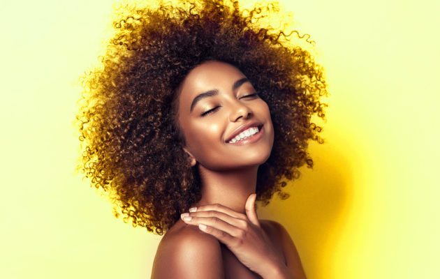 Woman of color smiling with Natural Hair