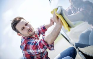 Man wiping the side of a car