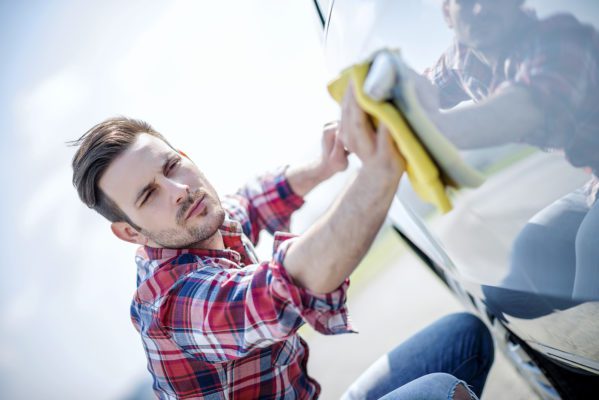 Man wiping the side of a car