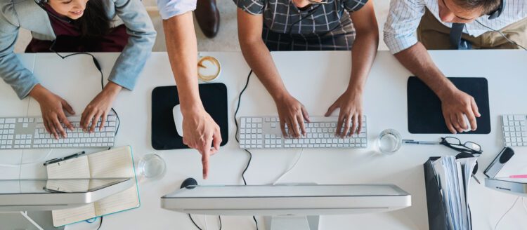 birds eye view of 4 people working on together on computers