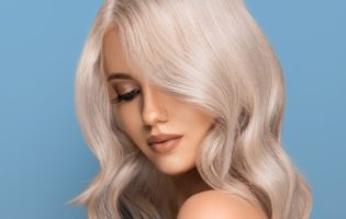 young white women with platinum blonde hair in front of blue background